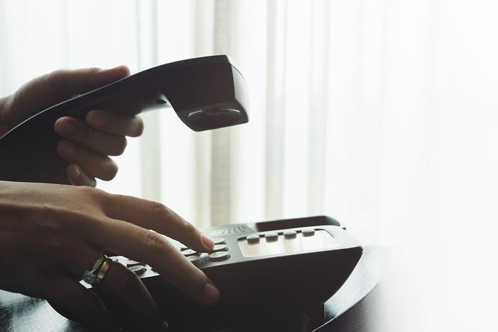 Woman's hand dialing on a business telephone