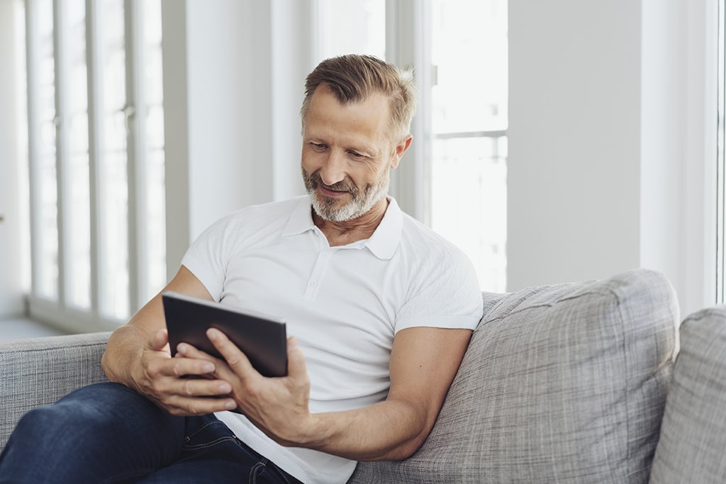 Mature gentleman using tablet to request service