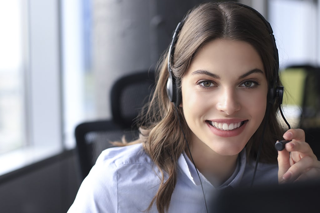 Smiling young woman wearing headset for business communication